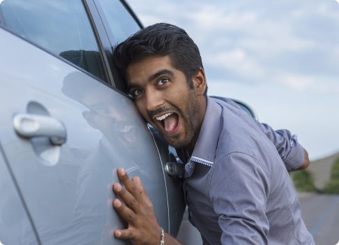 Man smiling next to a car